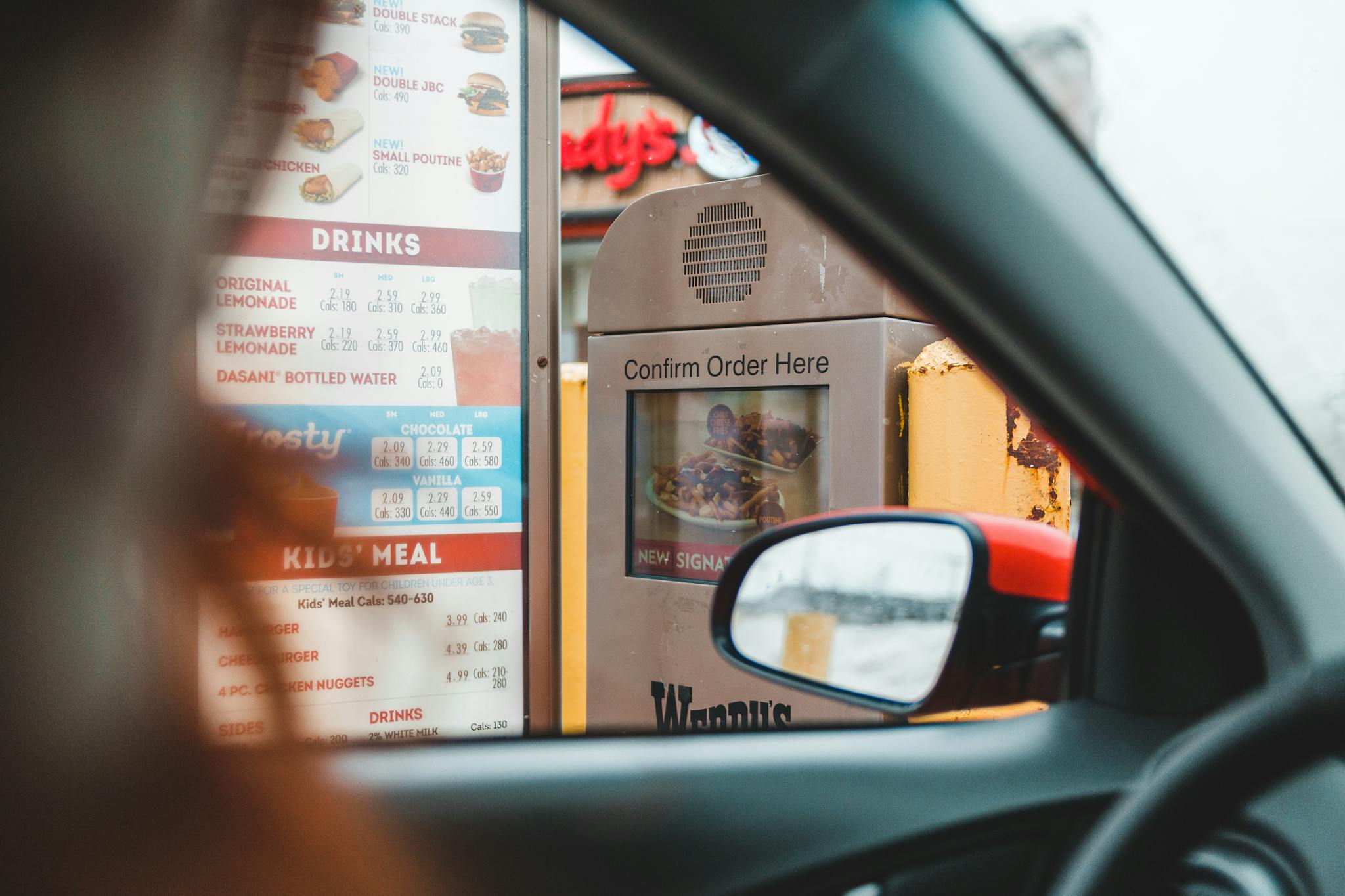 Person ordering fast food in drive thru